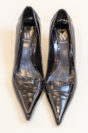 Black pointed-toe patent leather shoes.