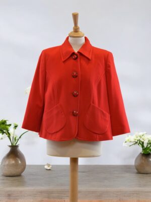 Short loose-cut red autumn jacket with fancy buttons.